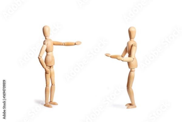 Fototapeta Two wooden toy mannequins doing speaking gestures isolated on a white background with copy space