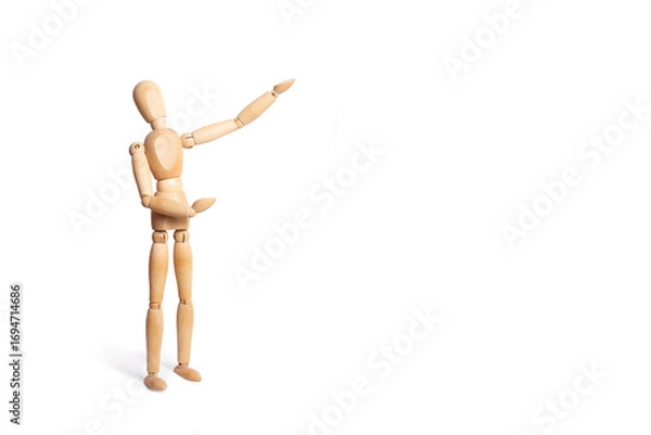 Fototapeta A wooden toy mannequin doing gesture of showing something isolated on a white background with copy space