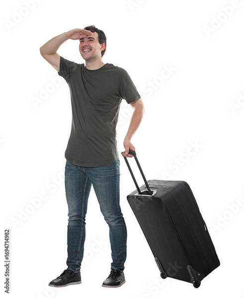 Fototapeta Contented man traveler carrying his rolling suitcase holding hand to forehead looking away in search for new travel adventures. Excited guy passenger portrait isolated on transparent background