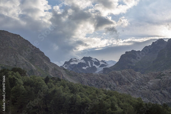 Fototapeta Горный пейзаж. Красивый вид на живописное ущелье, облачное небо над высокими горами. Природа Северного Кавказа
