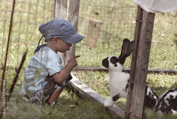 Obraz Junge spielt mit süssem Hase