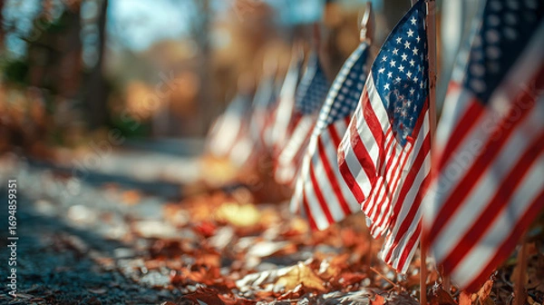 Fototapeta Row of american flags waving gently in soft autumn light with blurred fall foliage