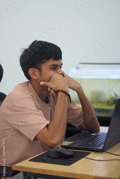 Fototapeta Stressed Man Holding Head While Working on Laptop in Office
