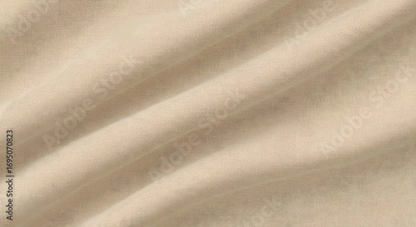 Fototapeta Close up of beige fabric with diagonal folds creating soft shadows and subtle texture detail visible