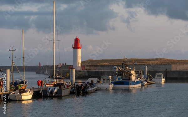 Obraz Peaceful fishing port of La Cotinière (on Oléron island) with its beautiful red and white lighthouse at sunset.