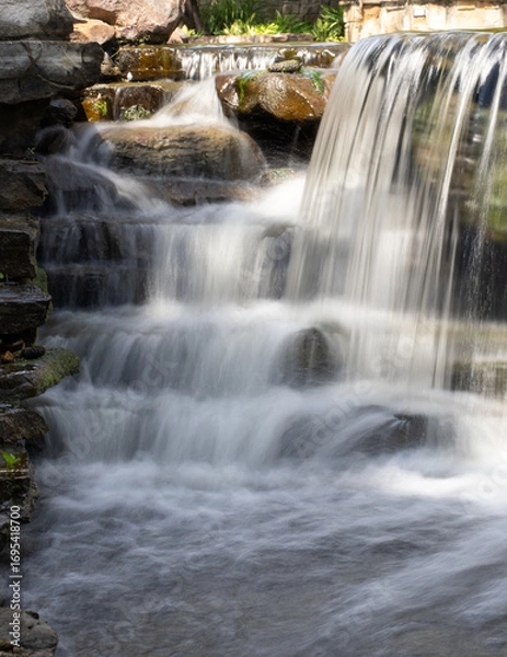 Fototapeta Close Up of a Manmade Waterfall Photographed with a Long Exposure in The Woodlands, Texas