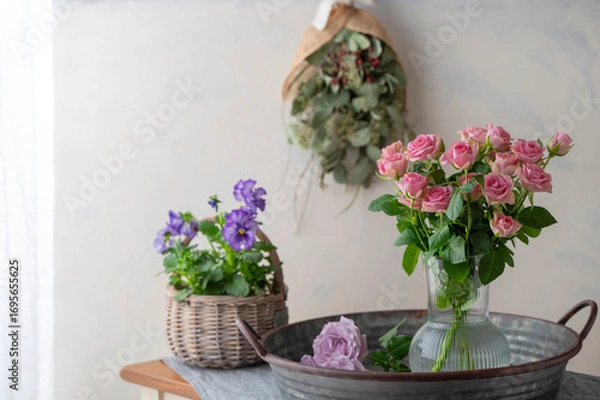 Obraz バラの花とビオラ　白い壁に飾られたユーカリのスワッグ