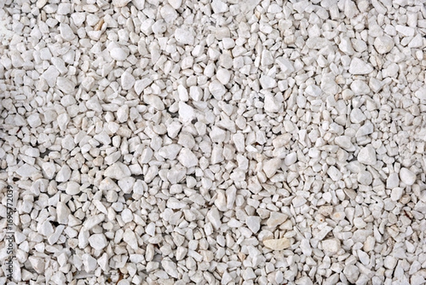 Fototapeta This image shows a close-up view of a surface covered with small irregularly shaped white rocks or pebbles