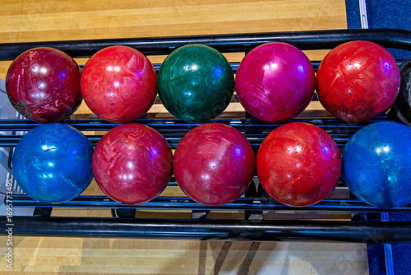 Fototapeta This image shows a set of ten bowling balls arranged on a rack