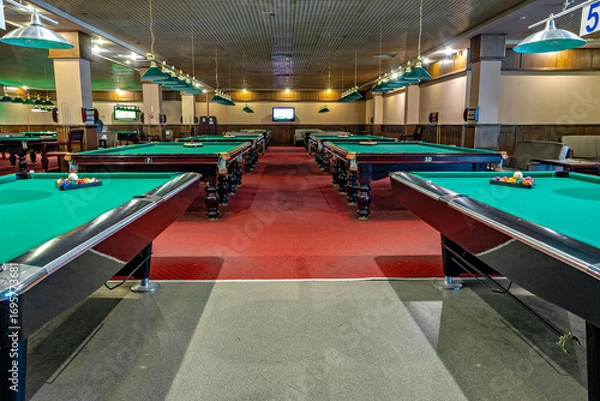 Fototapeta This image shows an indoor pool hall with several pool tables