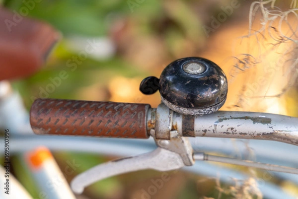 Fototapeta Close-up of a bell attached to a vintage bicycle handlebar.