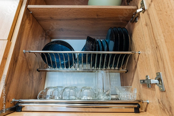 Fototapeta A welldesigned kitchen cabinet can hold an organized collection of plates, glasses, and a variety of other essential kitchenware, making it a crucial functional part of the home setting