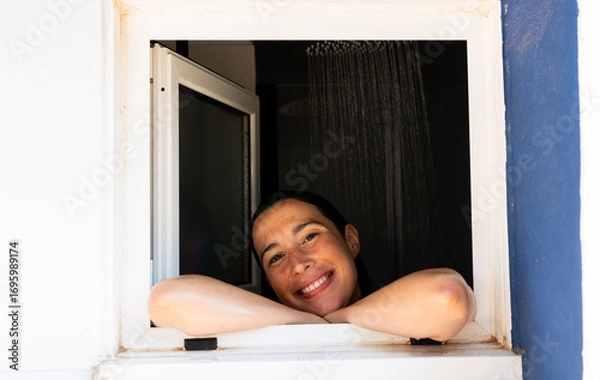 Fototapeta Woman smiling and relaxing in shower looking out window