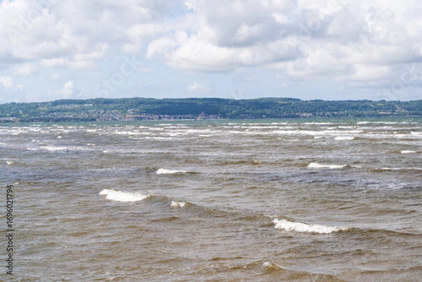 Fototapeta The stunning beach view in Southern Sweden and charming coastal town under a beautiful cloudy sky, Bostad, Sweden