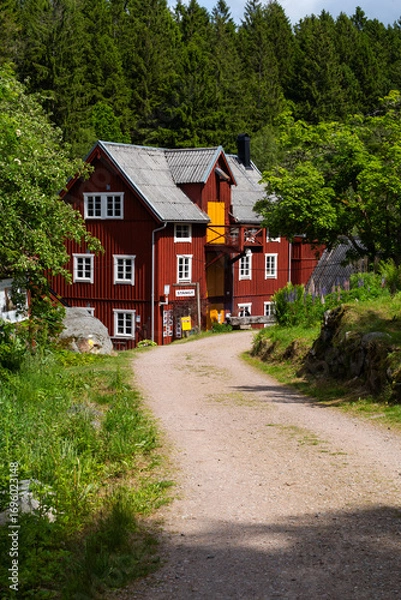 Fototapeta View at the old mill house by a river in a lush green forest Knared located in Southern Sweden.