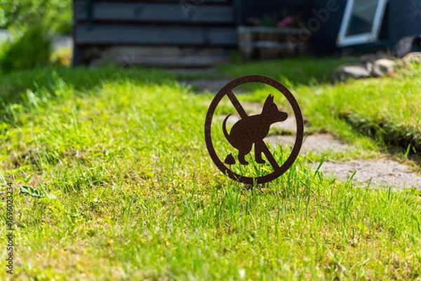 Fototapeta This is a prominently displayed Dog Restriction Sign that is placed in the lush green lawn area