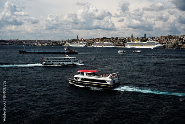 Fototapeta Costa Fortuna cruise ship and other little big ships on the Bosphorus of Istanbul. Ferries and passenger boats are visible cruising the Bosphorus, with large cruise ships in the background. Galata Tow