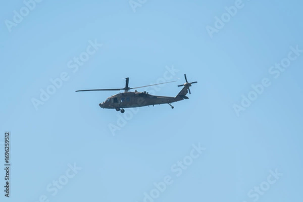Obraz Military helicopter flying in clear blue sky