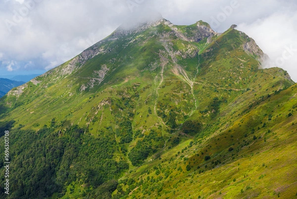 Fototapeta view of Mount Aibga-2 of the Caucasus Mountains in the clouds in summer