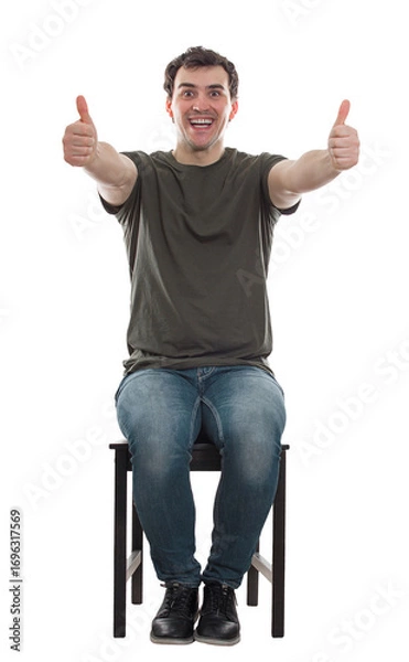 Fototapeta Excited man seated on a chair showing thumbs up, positive feedback, liking gesture. Positive male full length sitting portrait isolated on transparent background