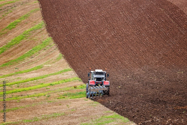 Fototapeta Tractor Ploughing Field on a slight incline