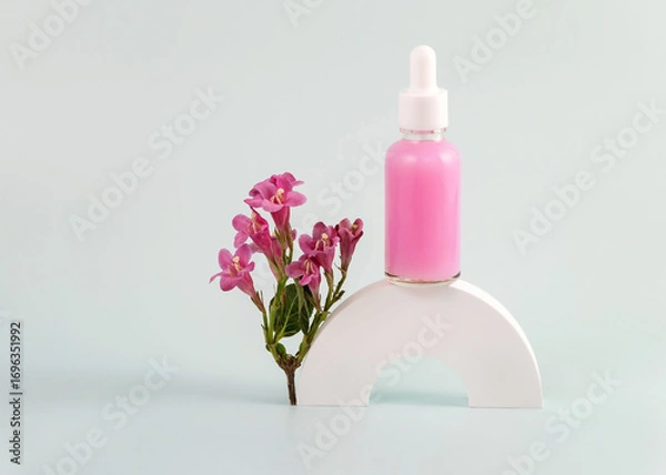 Fototapeta bottle of essential oil with a pipette and pink flowers on a white round podium. The concept of skin care using natural cosmetics