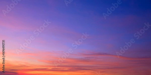 Fototapeta Twilight sky background with natural light and colorful orange sunlight cloud on blue evening sky in panoramic view