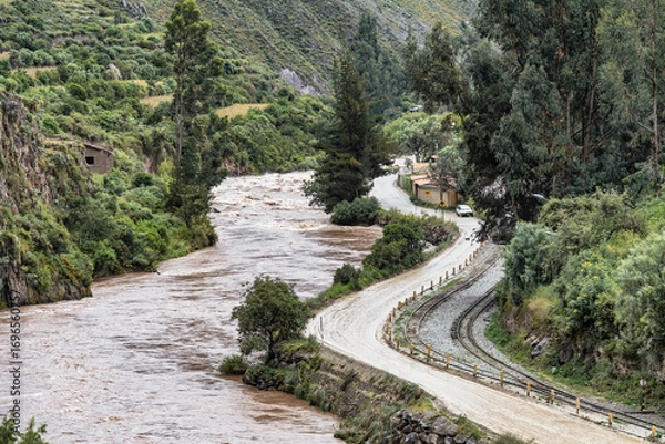 Fototapeta Scenic view of the Urubamba River flowing through the Sacred Valley alongside the Ollantaytambo town, Peru.