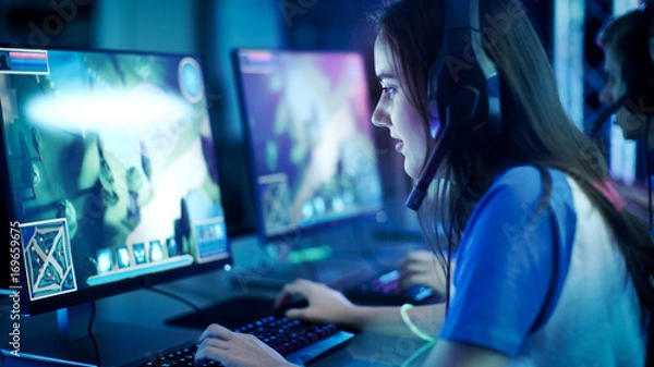 Obraz Professional Girl Gamer gra w MMORPG / strategiczną grę wideo na swoim komputerze. Bierze udział w turnieju online Cyber ​​Games, gra w domu lub w kafejce internetowej. Nosi gamingowy zestaw słuchawkowy.