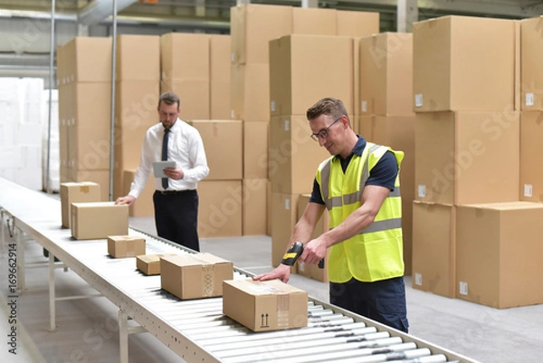 Obraz Arbeiter und Manager im Warenlager einer Spedition