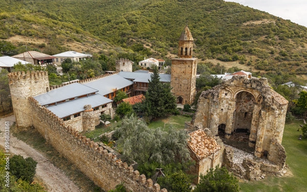 Fototapeta Drone view of Ninotsminda Cathedral complex with medieval stone walls, bell tower, and church ruins