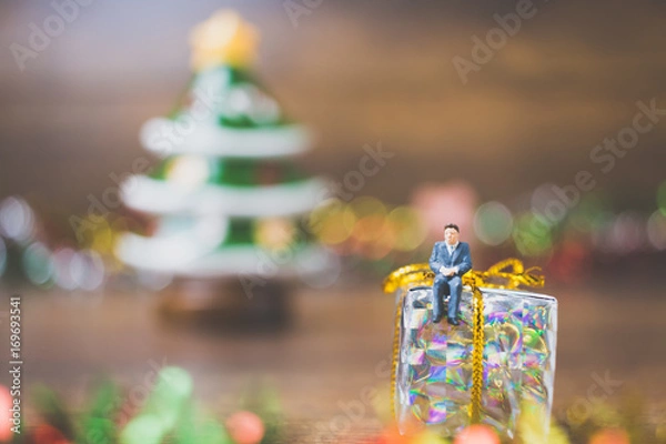 Obraz Miniature people on gift box with Christmas Day celebration background
