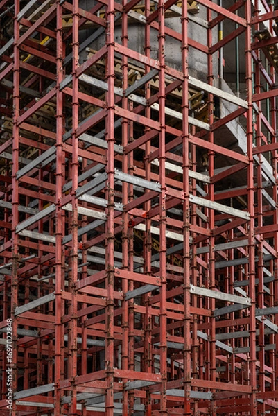 Fototapeta dense network metal scaffolding forms a complex geometric pattern. The chaotic but ordered structure, abstract composition, skeleton of a building.