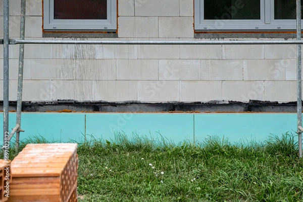 Fototapeta  foundation of a private house is prepared with a layer of green water resistant  foam insulation. The building wall is made of aerated concrete blocks, energy-efficient construction common in Europe