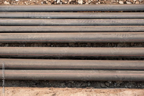 Fototapeta lay multiple communication cables in protective conduits inside an open trench wires remain exposed for inspection and connection infrastructure