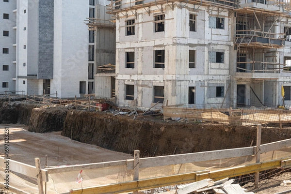 Fototapeta onstruction site in Israel shows a multi-story concrete building in progress. Excavated ground highlights active structural development
