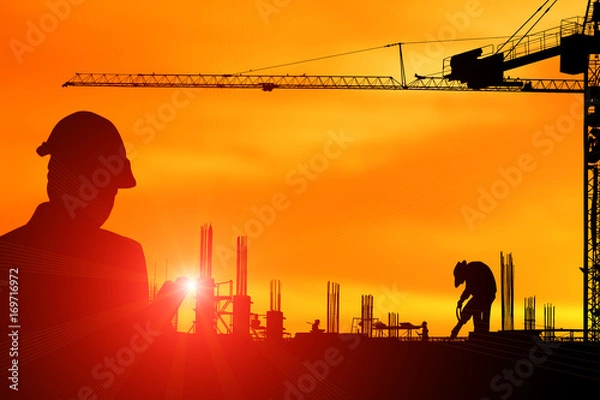 Fototapeta Silhouette construction engineer in the process of checking the construction site