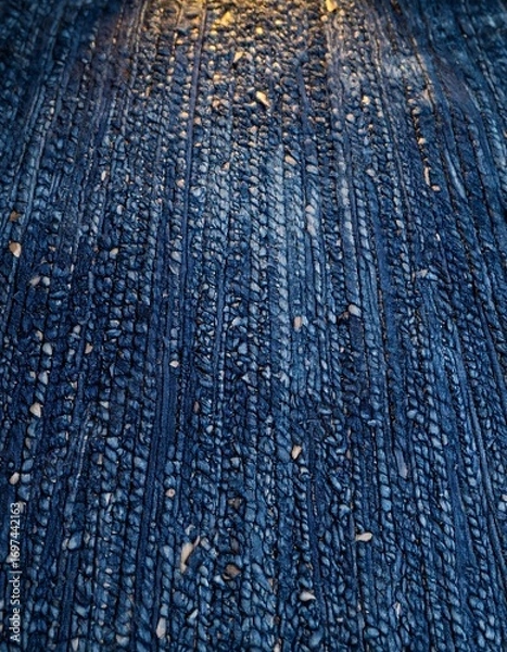 Fototapeta Dark, textured surface with vertical lines and small stones
