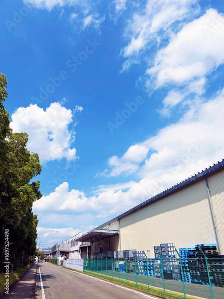 Fototapeta 道路沿いの工場と穏やかな青空