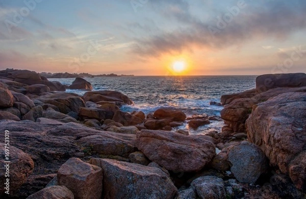 Fototapeta Dramatic sunset over the Pink Granite Coast in Brittany, France. Waves crashing on the rugged rocks, vibrant sky colors reflecting on the sea. Peaceful ocean landscape with natural stone formations.