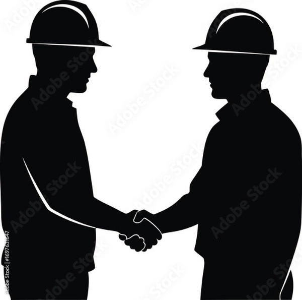 Fototapeta Silhouette of two construction workers in hard hats shaking hands, symbolizing teamwork