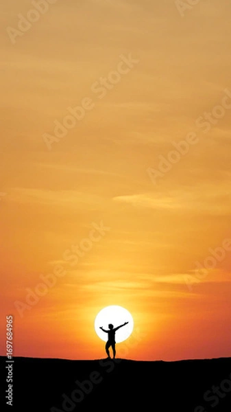 Fototapeta Silhouette of a person embracing Sunset: An emotive silhouette of a person stretches towards the vast, fiery sun, their arms wide open in a gesture of pure freedom.