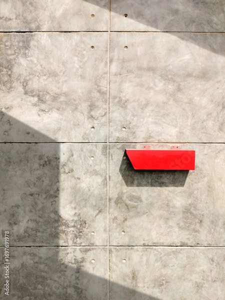 Fototapeta Red postbox on the old bare concrete wall in vintage loft style with sunlight and shadow on surface, front view and vertical frame