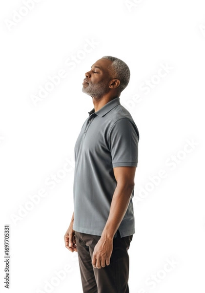 Fototapeta Elderly African man, salt-and-pepper hair, charcoal polo & dark chinos, eyes closed, head tilted, in a bright studio with transparent background, ample copy space, concept of serene introspection