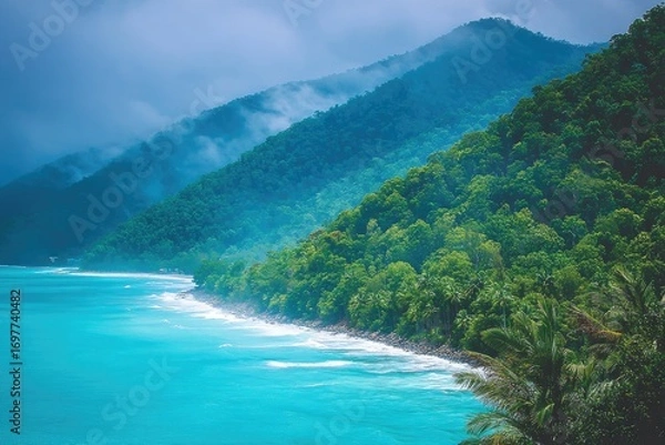 Fototapeta Lush tropical coastline with misty mountains