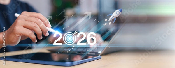 Fototapeta Businessman hand on laptop with digital 2026 goal, rocket launch and upward arrows. Futuristic concept of business growth, digital strategy, and vision planning.