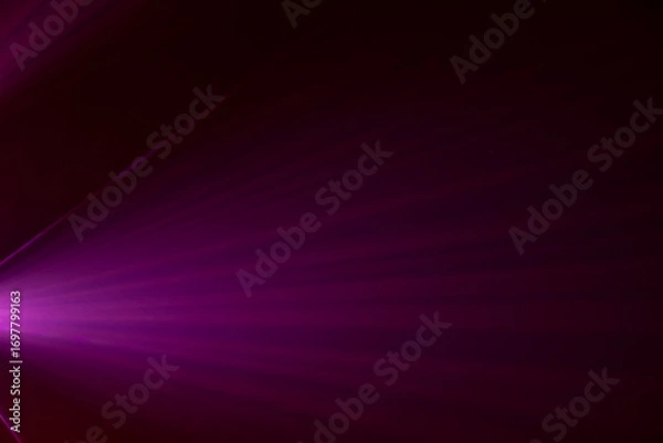Fototapeta intense purple spotlight beam emanating from a central point, creating a tunnel-like effect. The background is pitch black