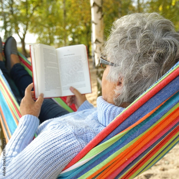 Fototapeta Peaceful Autumn Moments: Senior Relaxing in a Hammock by the Lake