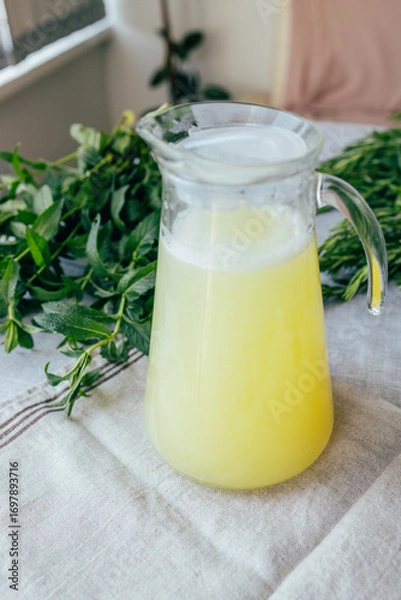 Fototapeta Homemade lemonade with mint, lemon and lime in a glass pitcher on the table. Refreshing drink, nutrition, healthy lifestyle