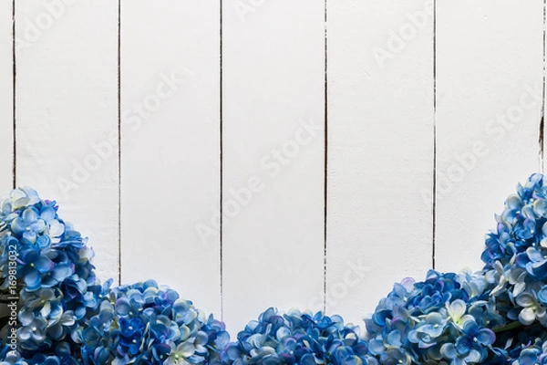 Obraz Blue hydrangea flowers on a white wooden texture background.Artificial Flowers